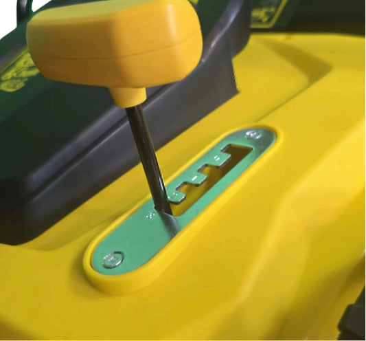 Close-up of a yellow and green lawn mower with a height adjustment slot.