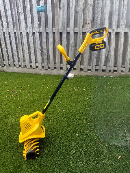 Garland 141W Artificial Lawn Sweeper on a artificail grass area with a wooden fence in the background